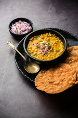 Dal pakwan is an authentic Sindhi breakfast. It is a combination of deepfried, crisp and unpuffed Maida puris served with Daal made using chana or split chickpea. selective focus