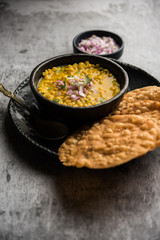 Dal pakwan is an authentic Sindhi breakfast. It is a combination of deepfried, crisp and unpuffed Maida puris served with Daal made using chana or split chickpea. selective focus