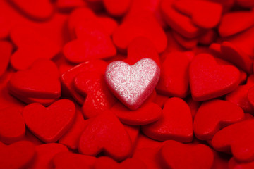 A lonely pink heart among many red hearts. The concept of loneliness in the crowd, St. Valentine's Day, special love