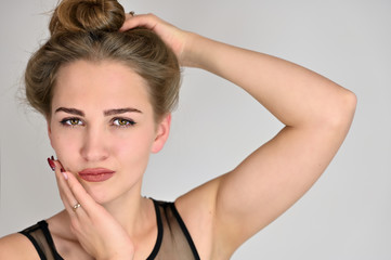 Obraz premium Generic female portrait concept for cosmetics advertising on a white background. A large photo of a pretty smiling girl with long hair and excellent make-up is standing in different poses.