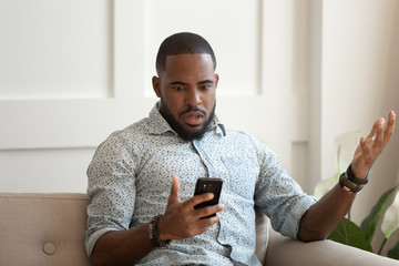 African man holds cellphone read sms feels shocked