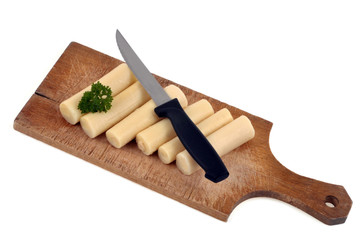 Cœurs de palmier sur une planche à découper sur fond blanc