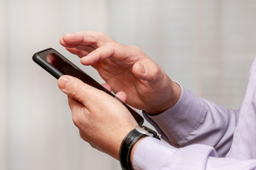 Cellphone in the hands of a man. Man with smartphone in office_