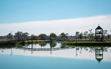  bridge on island with sky reflected in the river