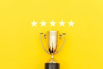 Simply flat lay design winner or champion gold trophy cup and 5 stars rating isolated on pink...