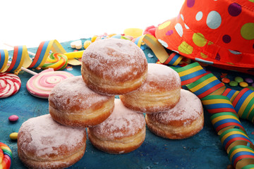 Carnival powdered sugar raised donuts with paper streamers. German berliner or krapfen for carnival