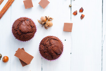 chocolate muffins with hazelnuts on white wooden