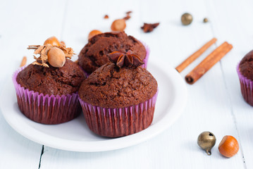 chocolate muffins with hazelnuts on white wooden
