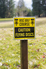 Disk golf course caution sign in park