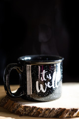 Black mug with it is well phrase and steam