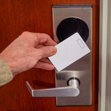 hand swiping key card to open hotel room door. Holding magnetic card for door access control swiping key card to lock and unlock door