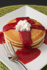 stack of pancakes with raspberry sauce