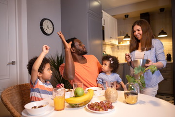 Mom puts a pot of food on the table for the whole family
