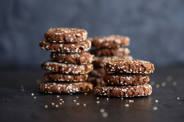 Healthy vegan low carb snack. Crispy chocolate sesam seed breakfast cookies on black background