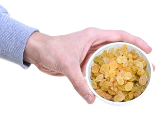 Hand holding bowl with raisins