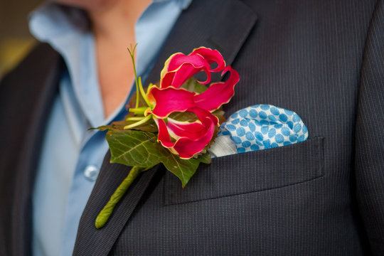 Colorful Pink orchid as a boutonniere in a Dark Groom Suit