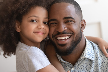 Close up faces portrait african daughter embraces father