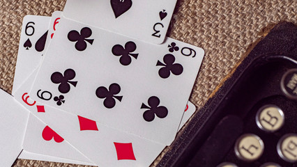 playing cards on burlap background near a typewriter. wallpaper