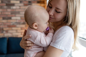 Young beautiful mother holding a newborn baby in her arms