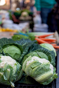 Coliflor, berzas y otras verduras en venta en un mercado al aire libre