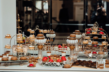 Wedding decoration with pastel colored cupcakes. Elegant and luxurious event arrangement. Luxury life. Delicious and tasty dessert table with cupcakes shots at reception closeup