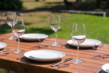 Served wooden table without a tablecloth. Cafe in the open air park