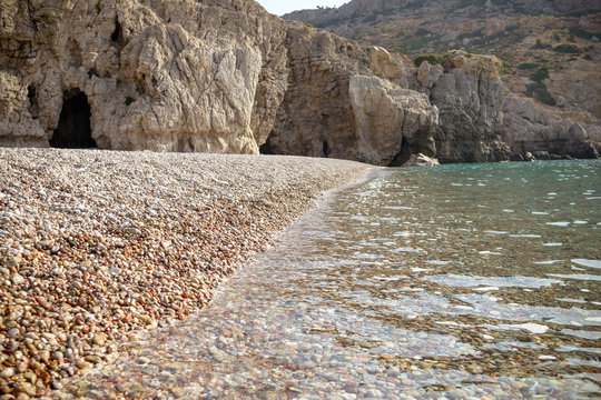 famous rocky beach of Traganou with iconic caves, Rhodes island, Dodecanese, Greece.view of the beautiful stones beach on the east coast of the island of Rhodes, Greece.Selective focus.