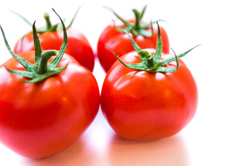 Four delicious ripe red tomatoes on white background. Side angle view. Healthy and organic food concept. Agriculture and harvesting. Vegetable store in supermarket. Illustration for price tag.