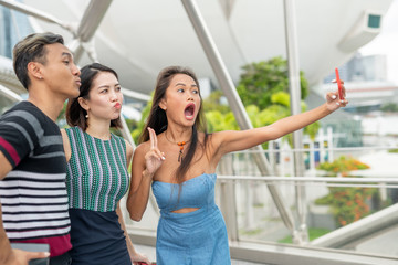 Three asian friends taking selfies outdoor. Friendship and holiday concept