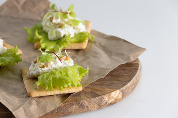 toast for Breakfast of tender, juicy sprouted beet sprouts with soft cheese, lettuce and wheat sprouts on a white on a wooden Board on a white background.