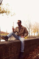 Handsome man enjoying in Paris while using cellphone.