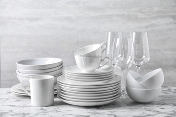 Set of clean dishware on marble table