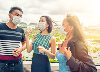 Group of Three young asian people wearing masks outdoor. Air masks protecting from diseases and illnesses