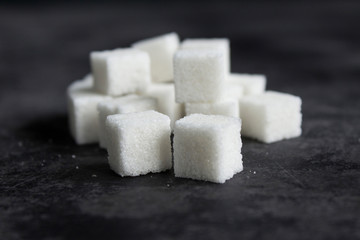 group of white sugar cubes on dark concrete surface