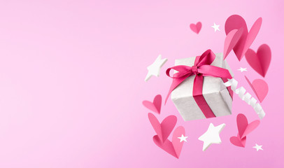 Fly or fall gift box, hearts, stars on pink background. Romantic background for Valentine Day, Mothers Day or Birthday. Space for text.
