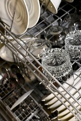 A basket of dishwashers with washed dishes and an accent on the top shelf of the grille.