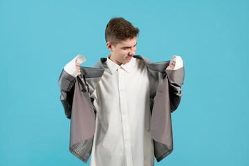 the boy in discontent looks at himself the office clothes of an adult.