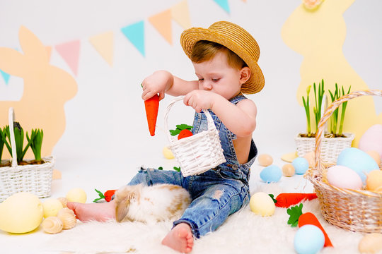 the boy with the rabbit. happy little boy in hat feeds cute fluffy Bunny. Friendship with Easter Bunny. Spring photo with little boy with his Bunny. boy is holding a cute little rabbit.
