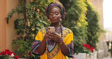 Portrait of the young African beautiful woman in the traditional clothes standing in the nice...