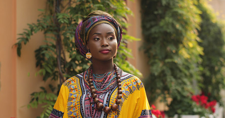 Close up of the face of the pretty young African woman in the traditional outfit looking at the...