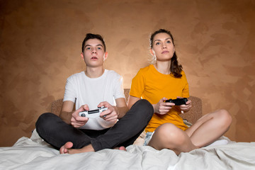 Brother and sister enthusiastically calmly play a video game using joysticks