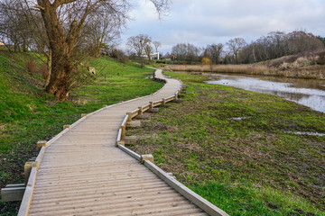 Fototapeta na wymiar new curved wooden footpath for walk in nature park