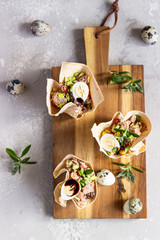 Tuna salad with cucumber, bell pepper, corn and quail egg in tartlets made from lavash. Healthy...