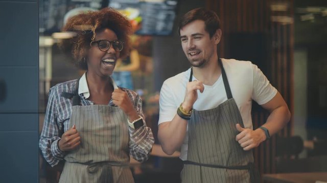 Young multicultural waiters dancing and having fun in restaurant