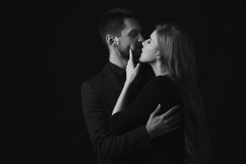 elegant couple in the tender passion. man and beautiful woman kissing. black and white