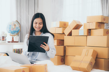 Young woman entrepreneur selling online product and use laptop in her workplace.