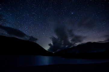 Night sky with clouds above lake in albanian nature near Fushe Stude, Albania