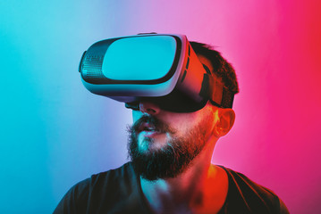 Man with Virtual Reality Glasses on a blue and red colored background.