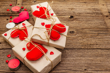 Zero waste gift concept. Valentine Day or Wedding eco friendly packaging. Festive boxes in craft paper with red felt hearts. Vintage wooden background