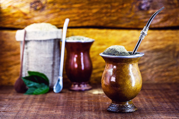Yerba mate tea in calabash on wooden table. Traditional Argentine, Uruguayan and Brazilian drink....